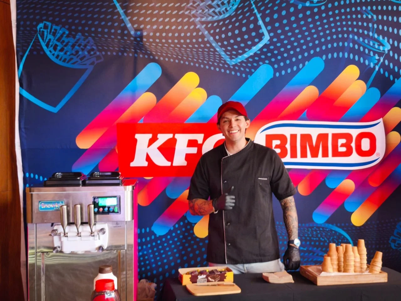 Operador junto a la máquina de helados y los conos en el evento Bimbo / KFC